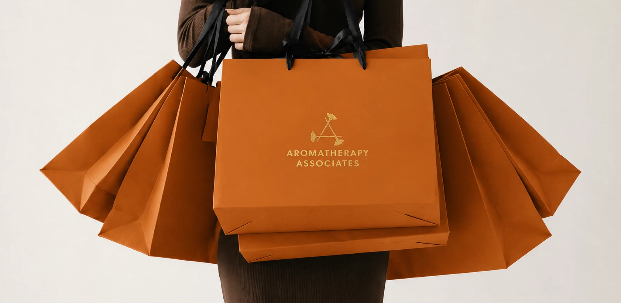 Aromatherapy Associates amber shopping bags carried by a customer