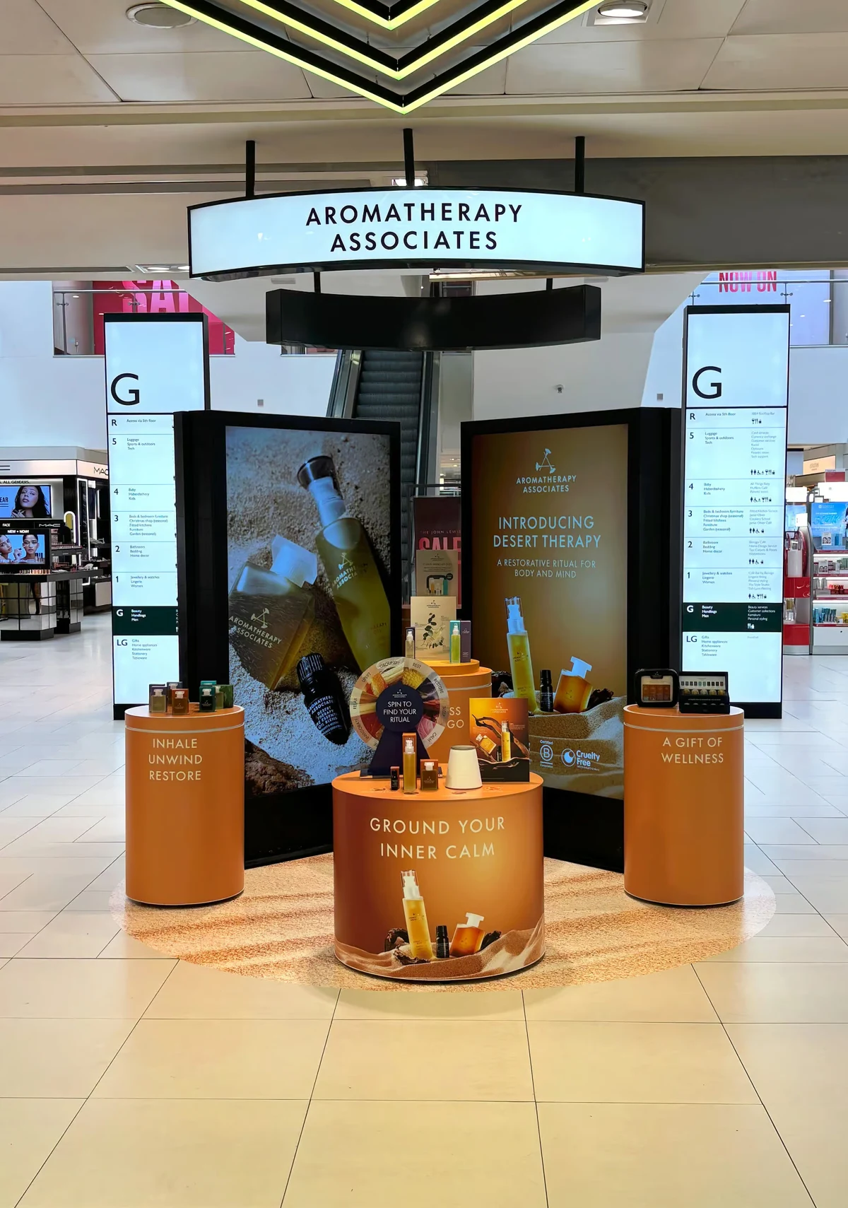 John Lewis activation with screen totems, amber product podiums and overhead brand signage