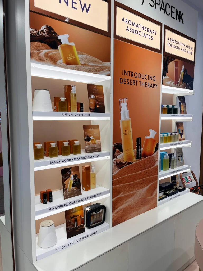 Close view of the Space NK shelving with amber campaign artwork and product information