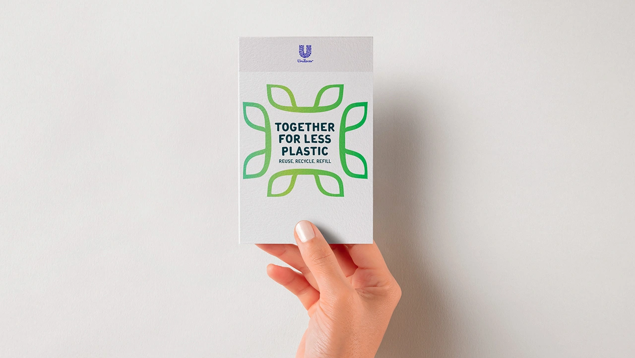Hand holding a Together for Less Plastic campaign card